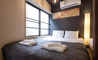 a bedroom with a bed with two towels on it at The Villa Ebisu BLUE\u60e0\u6bd4\u5bff\u99c5\u5f92\u6b658\u5206 \u9759\u304b\u306a\u4f4f\u5b85\u5730 in Tokyo