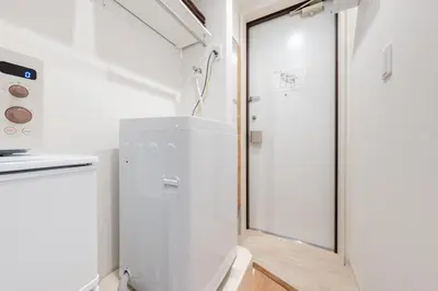 a small white refrigerator in a kitchen with a window at Urban Villa Sumida in Tokyo