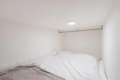 a bedroom with white walls and a bed with white pillows at Urban Villa Sumida in Tokyo