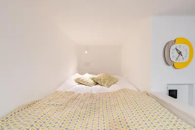 a bedroom with a bed and a clock on the wall at Urban Villa Sumida in Tokyo