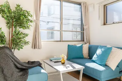 a living room with a blue couch and a table at Urban Villa Sumida in Tokyo