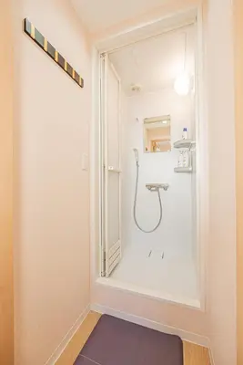 a bathroom with a shower with a glass door at Independent Home - One Minute Walk to Rail Hub - Direct Link to Asakusa Ueno Ginza Tokyo Sky Tower - 102 Square Meters with Four Rooms One Living Area Two Restrooms Two Baths - Easy Link to Both Major Airports in Tokyo