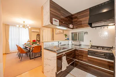 a kitchen with wooden cabinets and a dining room at Independent Home - One Minute Walk to Rail Hub - Direct Link to Asakusa Ueno Ginza Tokyo Sky Tower - 102 Square Meters with Four Rooms One Living Area Two Restrooms Two Baths - Easy Link to Both Major Airports in Tokyo