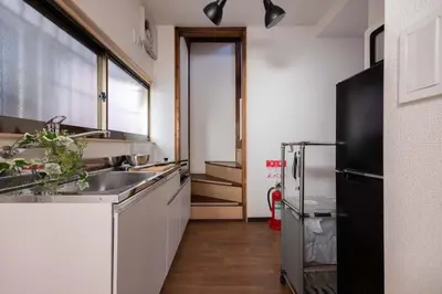 a kitchen with a sink and a black refrigerator at Omori House in Tokyo