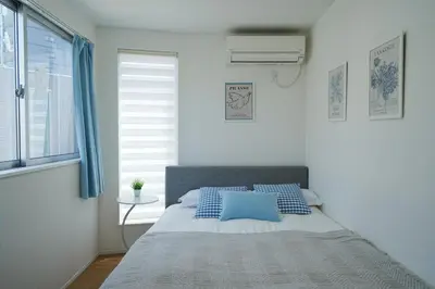 a bedroom with a bed with blue pillows and a window at Near Skytree 90sqm 4BDR! 4mins to station! in Tokyo