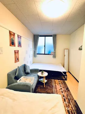 a room with a couch and a bed and a table at The Yumi Shinjuku in Tokyo