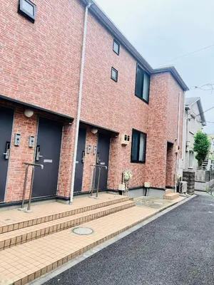 a red brick building with two doors and some stairs at The Yumi Shinjuku in Tokyo