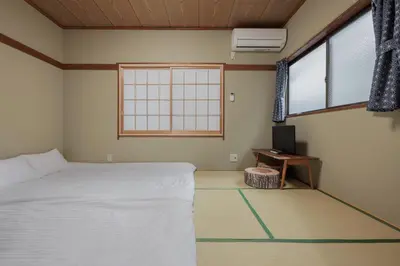 a bedroom with a bed and a tv and a window at self-check in-shinjuku-windhouse in Tokyo