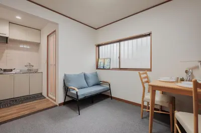 a kitchen with a table and a blue chair in a room at self-check in-shinjuku-windhouse in Tokyo