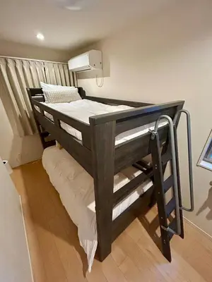 a wooden bunk bed in a small room with at \u6e0b\u8c375\u5206 \u65b0\u5bbf15\u5206 \u4e09\u8ed2\u8336\u5c4b\u99c5\u5f92\u6b694\u5206 8\u540d\u5bbf\u6cca\u53ef \u4e00\u68df\u8cb8\u5207 24\u6642\u9593\u30b9\u30fc\u30d1\u30fc\u5f92\u6b693\u5206 in Tokyo