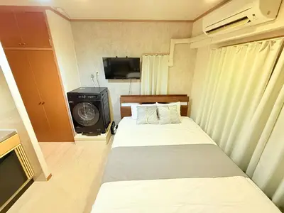 a small room with two beds and a television at P-Yamanote Line shinjuku \u9ad8\u7530\u99ac\u5834 5mins walk Hostel! \u9ad8\u901fWi-fi! Waseda in Tokyo