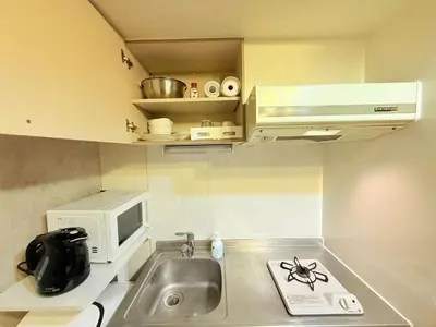 a small kitchen with a sink and a microwave at P-Yamanote Line shinjuku \u9ad8\u7530\u99ac\u5834 5mins walk Hostel! \u9ad8\u901fWi-fi! Waseda in Tokyo