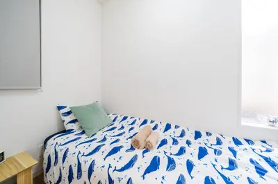 a bed with a teddy bear sitting on top of it at QiQi House Elegance in Sumida Yahiro Skytree Views & High-End Comfort for 6 people in Tokyo