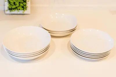 three white plates and bowls sitting on a table at QiQi House Elegance in Sumida Yahiro Skytree Views & High-End Comfort for 6 people in Tokyo