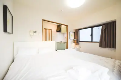 a bedroom with two white beds and a window at self-check in-\u30ef\u30b3\u30fc\u30c9\u76ee\u767d in Tokyo