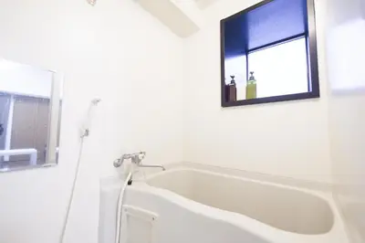 a white bath tub in a bathroom with a window at self-check in-\u30ef\u30b3\u30fc\u30c9\u76ee\u767d in Tokyo