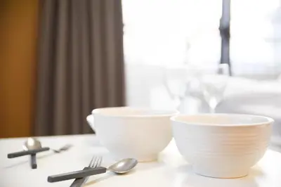 two white bowls and spoons on a table at self-check in-\u30ef\u30b3\u30fc\u30c9\u76ee\u767d in Tokyo