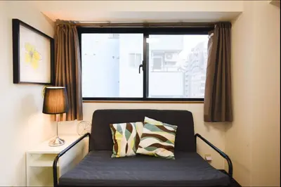 a bed in a room with a window at self-check in-\u30ef\u30b3\u30fc\u30c9\u76ee\u767d in Tokyo