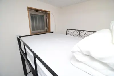 a bed in a room with a window at SOKOResort Asakusa in Tokyo