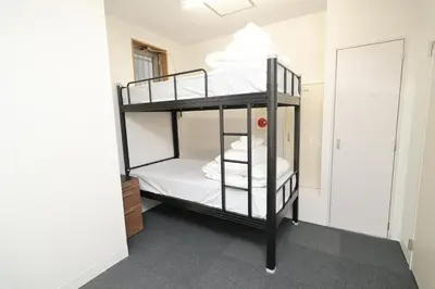 a bunk bed in a room with white walls at SOKOResort Asakusa in Tokyo