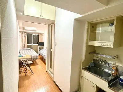 a kitchen with a sink and a room with a bed at Tokyo West Shinjuku Entire House in Nishishinjuku-gochome in Tokyo