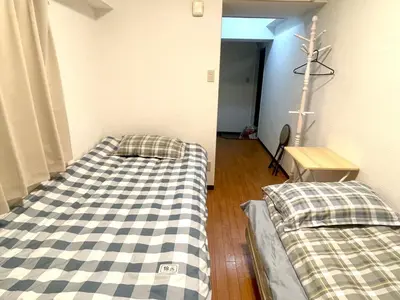 a room with two beds and a cross on the wall at Tokyo West Shinjuku Entire House in Nishishinjuku-gochome in Tokyo