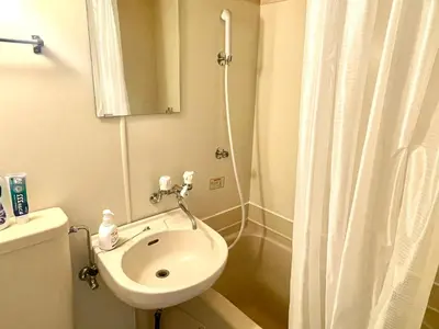 a white bathroom with a sink and a shower at Tokyo West Shinjuku Entire House in Nishishinjuku-gochome in Tokyo