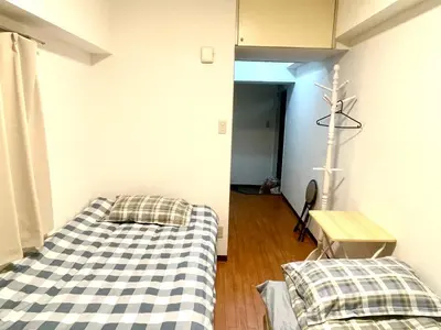 a room with two beds and a cross on the wall at Tokyo West Shinjuku Entire House in Nishishinjuku-gochome in Tokyo