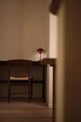 a room with a table with a chair and a lamp at Urban House Koenji in Tokyo