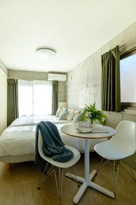 a bedroom with a bed and a table and chairs at DeLIGHT HOTEL in Tokyo