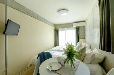 a room with a bed and a table and a tv at DeLIGHT HOTEL in Tokyo