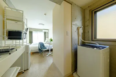 a room with a kitchen with a sink and a table at DeLIGHT HOTEL in Tokyo