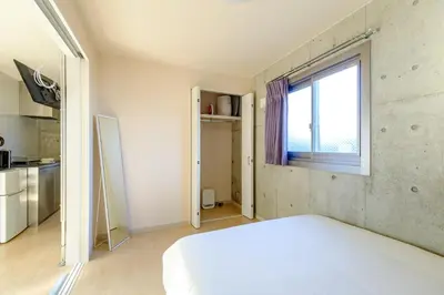 a bedroom with a white bed and a window at DeLIGHT HOTEL in Tokyo