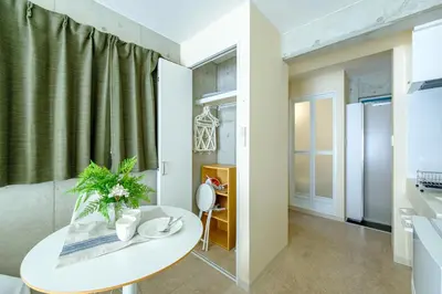 a living room with a white table and a green curtain at DeLIGHT HOTEL in Tokyo