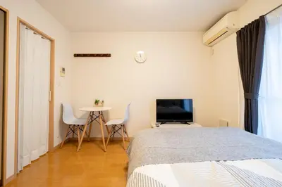 a bedroom with a bed and a table and a tv at Belle Lead in Tokyo