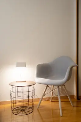 a white chair next to a table with a lamp at Belle Lead in Tokyo