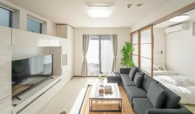 a living room with a couch and a tv at \u6075\u6bd4\u5bff\u99c5\u5f92\u6b695\u5206 4ldk \u8cb8\u5207\u4e00\u8ed2\u5bb6 \u30a8\u30ec\u30d9\u30fc\u30bf\u30fc\u3042\u308a in Tokyo