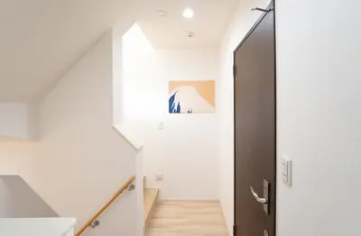 a hallway with white walls and a staircase with a door at \u6075\u6bd4\u5bff\u99c5\u5f92\u6b695\u5206 4ldk \u8cb8\u5207\u4e00\u8ed2\u5bb6 \u30a8\u30ec\u30d9\u30fc\u30bf\u30fc\u3042\u308a in Tokyo