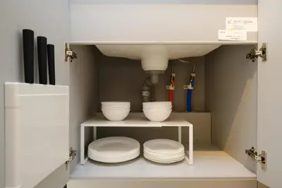a kitchen with bowls on a shelf under a sink at Cozy 2-Floor Retreat near Ikebukuro - Easy Access to Central Tokyo - \u30a2\u30ad\u30b5\u30dd\u30b9\u30c6\u30a4\u672c\u84ee\u6cbc in Tokyo