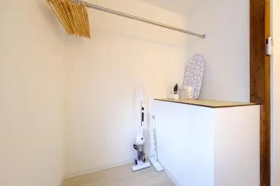 a white refrigerator in a room with a wall at Cozy 2-Floor Retreat near Ikebukuro - Easy Access to Central Tokyo - \u30a2\u30ad\u30b5\u30dd\u30b9\u30c6\u30a4\u672c\u84ee\u6cbc in Tokyo