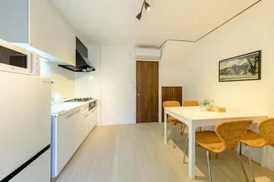 a kitchen and dining room with a white table and chairs at Cozy 2-Floor Retreat near Ikebukuro - Easy Access to Central Tokyo - \u30a2\u30ad\u30b5\u30dd\u30b9\u30c6\u30a4\u672c\u84ee\u6cbc in Tokyo