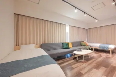 a living room with two beds and a couch at Blossom House Akasaka 401 in Tokyo