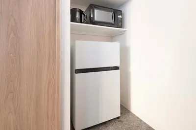 a small kitchen with a white refrigerator and a microwave at Blossom House Akasaka 401 in Tokyo