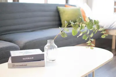 a living room with a table with a glass vase on it at Blossom House Akasaka 401 in Tokyo