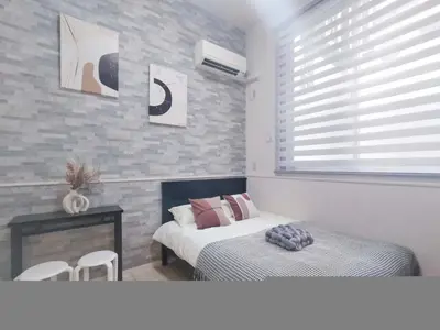 a bedroom with two beds and a table and a window at \u65b0\u5bbf\u4e2d\u5fc3\u5546\u5708-\u65b0\u5927\u4e45\u4fdd\u5f92\u6b654\u5206-\u65b0\u5bbf\u5f92\u6b6510\u5206-2Room-Max4P in Tokyo