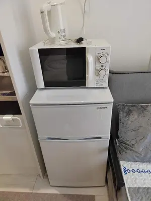 a microwave oven sitting on top of a refrigerator at \u6771\u4eac\u5929\u7a7a\u4e4b\u5bb6\u6c11\u5bbf201\u72ec\u7acb\u516c\u5bd3 \u72ec\u7acb\u536b\u6d74 in Tokyo