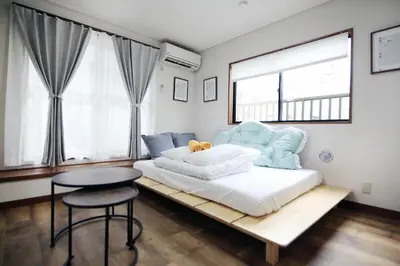 a bedroom with a large bed with a table and a stool at nakano102 in Tokyo