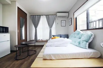 a bedroom with a bed and a table and a window at nakano102 in Tokyo