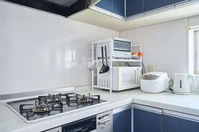 a kitchen with a stove top oven next to a microwave at JR ChuoLine Aasagaya station 5min,Shinjuku 8min Max15pp 2WC in Tokyo