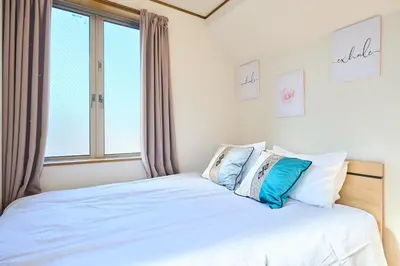a bedroom with a bed with blue and white pillows at JR ChuoLine Aasagaya station 5min,Shinjuku 8min Max15pp 2WC in Tokyo